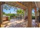Outdoor wooden deck area with a grill, dining table, and mature shade trees at 9665 2Nd N St, St Petersburg, FL 33702