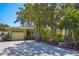 Lovely one-story home with mature trees and a driveway in front of the garage at 9665 2Nd N St, St Petersburg, FL 33702