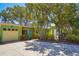 Charming yellow home featuring colorful trim, well-maintained landscaping, and a private driveway at 9665 2Nd N St, St Petersburg, FL 33702