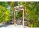 A comfortable outdoor seating area is set beneath a decorative pergola in a lush setting at 9665 2Nd N St, St Petersburg, FL 33702