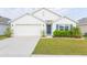 White house with blue shutters, two-car garage, and landscaped lawn at 1024 Golden Shiner Ave, Ruskin, FL 33570