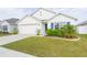 White house with blue shutters, two-car garage, and landscaped lawn at 1024 Golden Shiner Ave, Ruskin, FL 33570