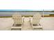 Two white Adirondack chairs sit on a sandy beach overlooking a calm lake at 11550 Lake Lucaya Dr, Riverview, FL 33579