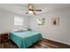 Cozy bedroom featuring wood floors, a ceiling fan, and a bright window with natural light at 1159 Stewart Dr, Dunedin, FL 34698