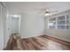 This bedroom features wood floors, a ceiling fan, and a large window for natural light at 1159 Stewart Dr, Dunedin, FL 34698