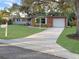 Brick ranch home with a well-manicured lawn and a long driveway at 1159 Stewart Dr, Dunedin, FL 34698