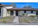 Front view of a light-yellow single-story home with a brown roof and walkway at 1311 Powderpuff Dr # 1003, Dunedin, FL 34698