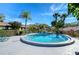 Inviting community pool with palm trees and clear water at 1311 Powderpuff Dr # 1003, Dunedin, FL 34698