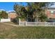 Home's exterior showcasing a brick facade and white picket fence at 13716 Orange Sunset Dr, Tampa, FL 33618