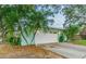 Attached garage with a long driveway and mature landscaping at 13851 102Nd Ave, Largo, FL 33774