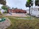 Brick patio, pool, and grassy backyard with palm trees at 15806 Redington Dr, Redington Beach, FL 33708