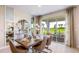 Dining room with a wooden table, patio doors, and view of a grassy backyard at 17921 Tavernside Trl, Lakewood Ranch, FL 34211