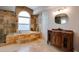 Bathroom with soaking tub, vanity, and stone tile at 18809 Chaville Rd, Lutz, FL 33558