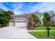 Two-story house with a three-car garage and manicured lawn at 18809 Chaville Rd, Lutz, FL 33558