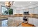 Bright kitchen featuring white cabinets, granite countertops, and stainless steel appliances at 18809 Chaville Rd, Lutz, FL 33558