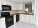 Kitchen with white cabinets, granite counters, and black appliances at 19029 Us Highway 19 N # 23C, Clearwater, FL 33764