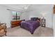 Spacious bedroom with wood dresser and purple bedding at 20 Sylvia Pl, Oldsmar, FL 34677