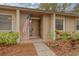 Front entrance of condo, featuring a wooden door and American flag at 20 Sylvia Pl, Oldsmar, FL 34677