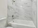 Updated bathroom featuring a white bathtub and marble-look tile at 2204 E 12Th Ave, Tampa, FL 33605