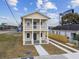 Two-story house with light yellow siding, balcony, and driveway at 2204 E 12Th Ave, Tampa, FL 33605