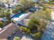 An aerial view of a home with a pool and solar panels on the roof, surrounded by lush tropical foliage at 2215 Cedar Dr, Dunedin, FL 34698