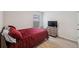 Cozy bedroom with a comfortable red bed and wood-look floors at 2812 Gumbo Limbo Dr, Wimauma, FL 33598