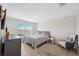 Main bedroom with king bed, window, and additional seating at 2812 Gumbo Limbo Dr, Wimauma, FL 33598