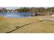 Community lake with a wooden dock and grassy areas at 3020 Moss Hill St, Wesley Chapel, FL 33543