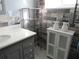 Stylish bathroom featuring gray vanity with modern fixtures and an open shelving unit at 3060 64Th N Ave, St Petersburg, FL 33702