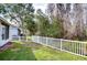 Landscaped backyard with a white fence and mature trees at 30817 Prout Ct, Wesley Chapel, FL 33543