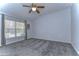 Bright bedroom with grey carpet, ceiling fan, and window with curtains at 30817 Prout Ct, Wesley Chapel, FL 33543