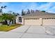 House exterior featuring a three-car garage and well-manicured lawn at 30817 Prout Ct, Wesley Chapel, FL 33543