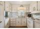 Galley kitchen with white cabinets and appliances at 36810 Kay Ave, Zephyrhills, FL 33542