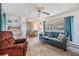 Living room with blue sofa, recliner, and a view into the dining area at 36810 Kay Ave, Zephyrhills, FL 33542