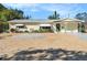 Yellow house with green awnings and a gravel driveway at 3992 60Th N St, St Petersburg, FL 33709