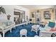 Bright sunroom with white wicker furniture and blue carpet at 3992 60Th N St, St Petersburg, FL 33709