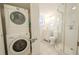 Small bathroom with shower, toilet, vanity, and stackable washer/dryer at 404 Manor Blvd, Palm Harbor, FL 34683