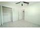 Bedroom with tile floors, mirrored closet doors, and ceiling fan at 404 Manor Blvd, Palm Harbor, FL 34683