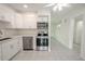 Modern kitchen with white cabinets, stainless steel appliances, and tile floors at 404 Manor Blvd, Palm Harbor, FL 34683