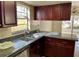 L-shaped kitchen with granite countertops and dark wood cabinets at 4814 Northdale Blvd, Tampa, FL 33624