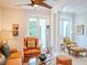 Living room with orange sofas and armchairs, a glass coffee table and access to a patio at 4818 W San Rafael St, Tampa, FL 33629