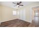 Bright bedroom with wood-look floors, ceiling fan, and double doors to closet at 4918 Cresthill Dr, Tampa, FL 33615