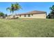 Spacious backyard with lush grass and palm trees at 4935 Marble Springs Cir, Wimauma, FL 33598