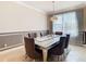 Formal dining room features a silver table, gray chairs, and large windows at 4935 Marble Springs Cir, Wimauma, FL 33598