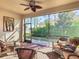 Relaxing screened porch with wicker furniture and ceiling fan at 4935 Marble Springs Cir, Wimauma, FL 33598