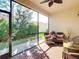 Bright screened porch with wicker furniture and ceiling fan at 4935 Marble Springs Cir, Wimauma, FL 33598