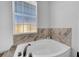 Corner bathtub with marble surround and window at 614 105Th N Ln, St Petersburg, FL 33716