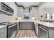 Modern kitchen with gray cabinets, stainless steel appliances, and chevron backsplash at 614 105Th N Ln, St Petersburg, FL 33716