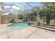 Relaxing screened-in pool with spa and lush landscaping at 660 Geneva Pl, Tampa, FL 33606