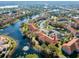 Aerial view of condos surrounding a lake with fountains, parking, and lush greenery at 6816 Dali Ave # E206, Land O Lakes, FL 34637